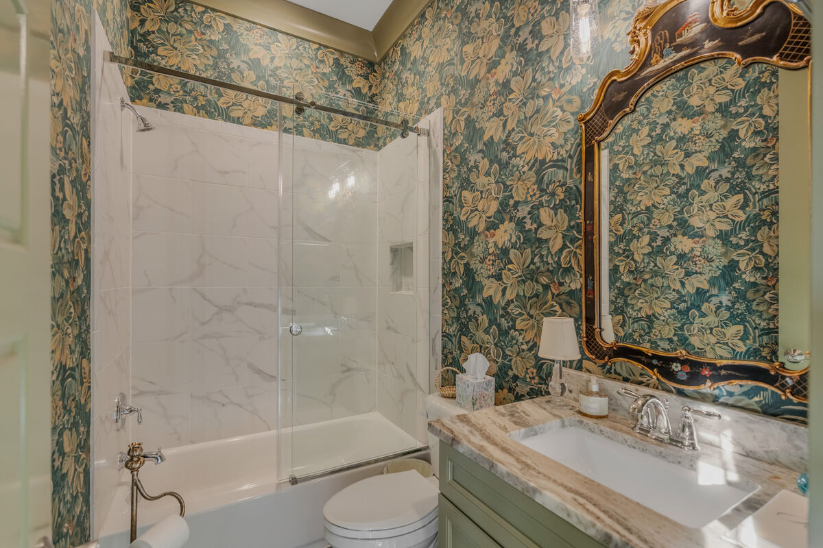 Main-level full bath in green and gold wallcovering